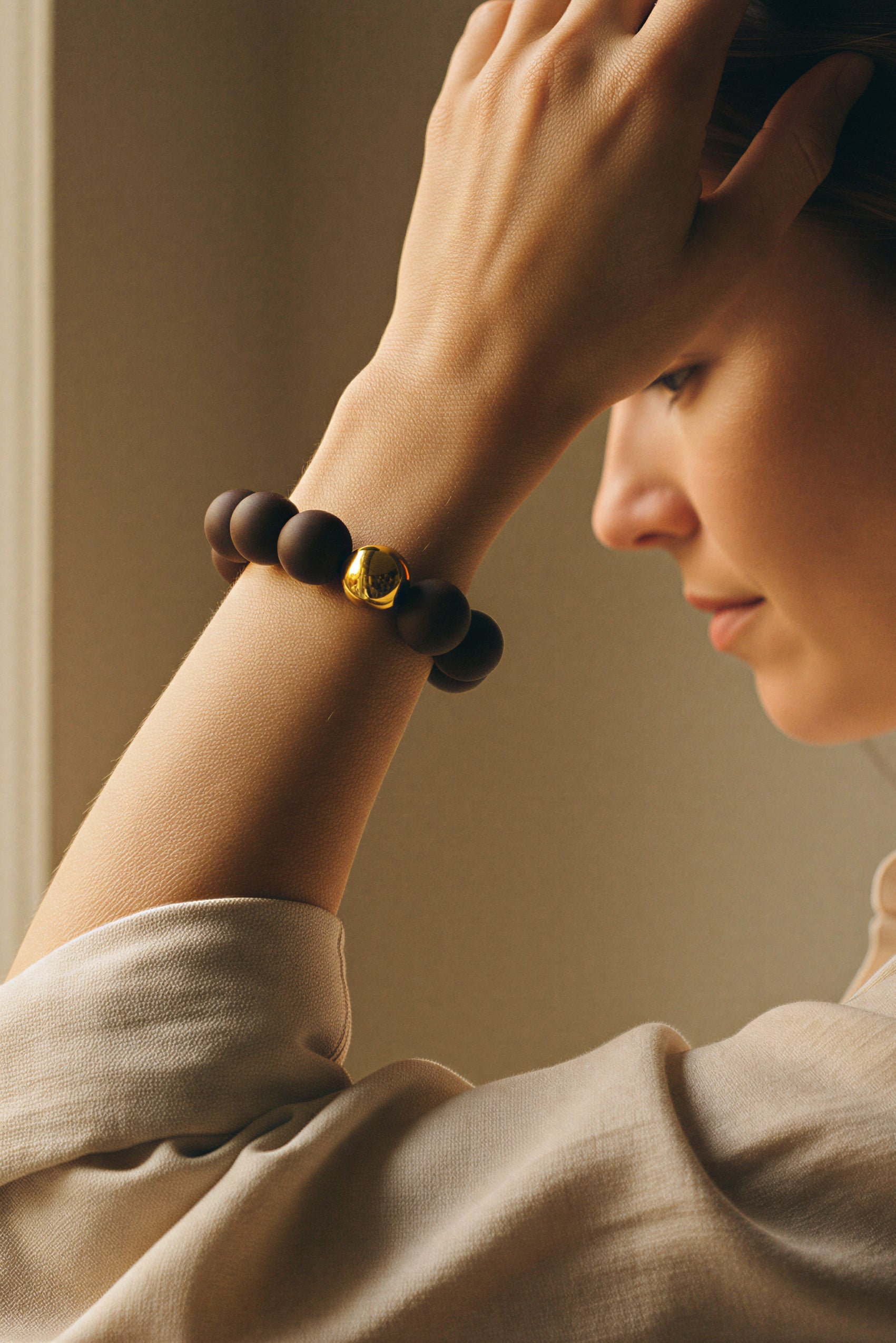 Armband aus Acryl in Dunkelbraun mit Goldkugel