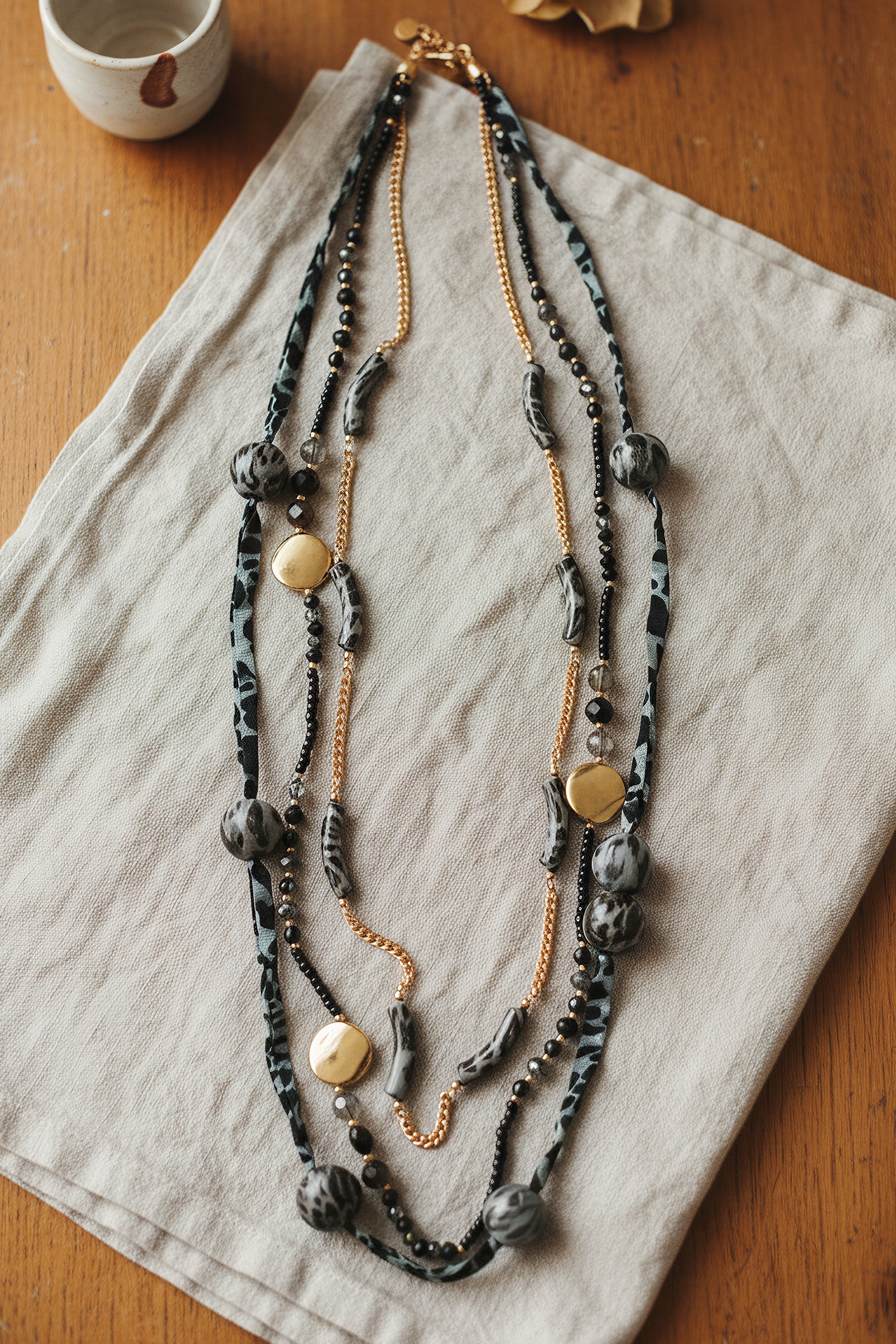 Lange Statement-Kette mit Stoffdetails und Goldakzenten