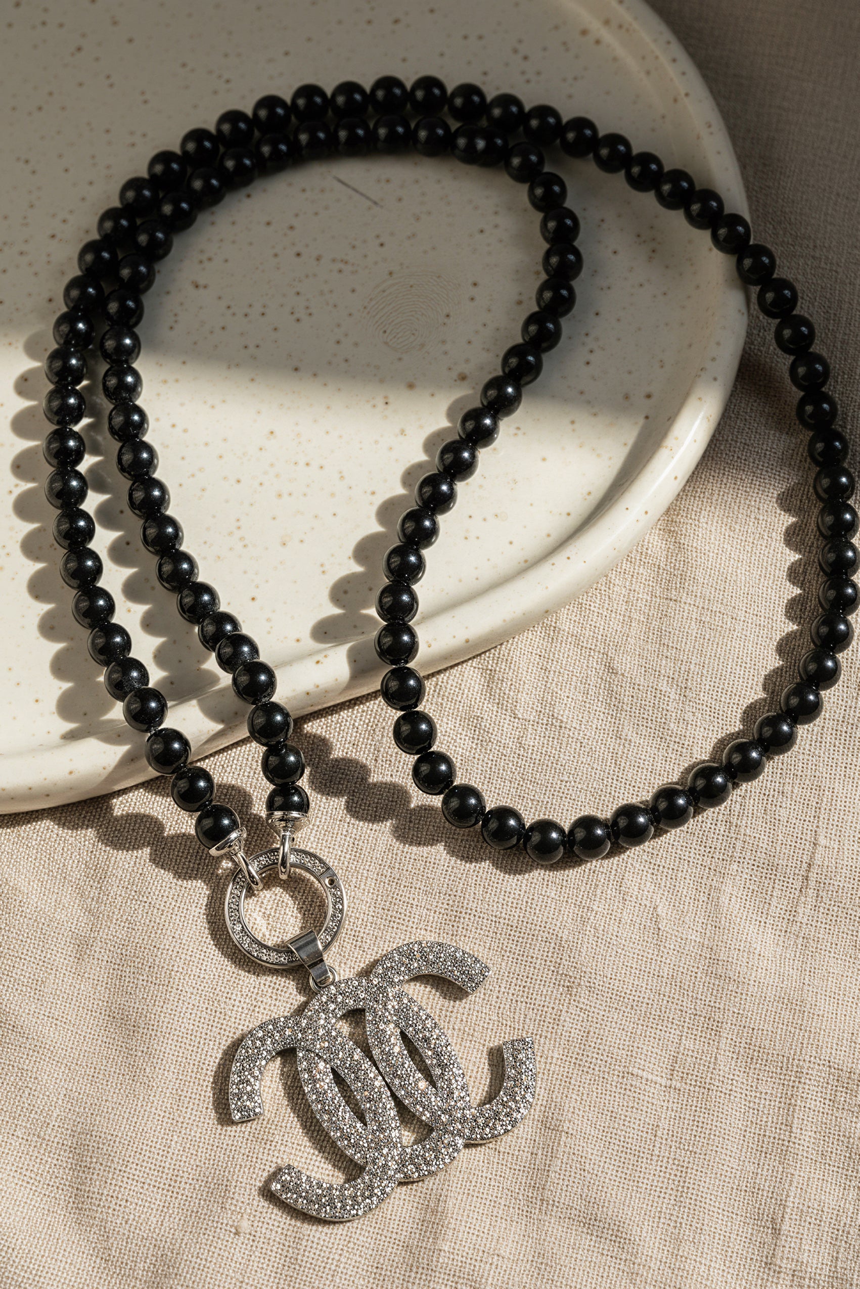 Schwarze Perlenkette mit Anhänger mit Strasssteinen besetzt