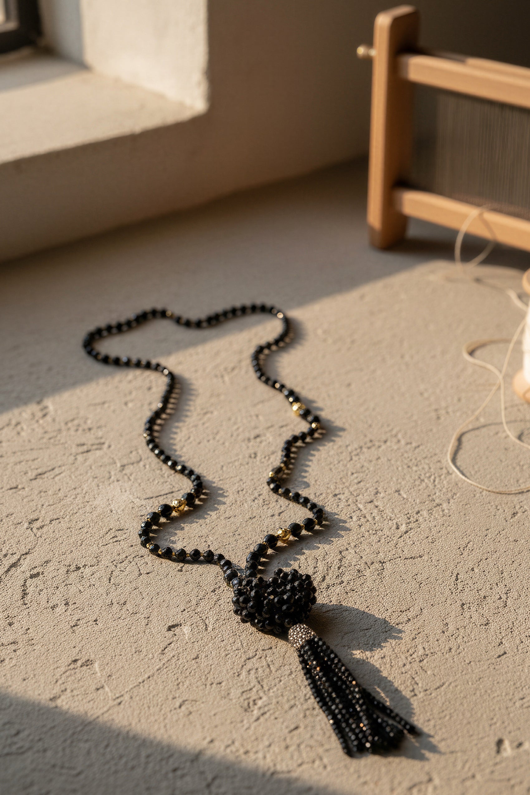 Lange schwarze Glasperlenkette mit funkelndem Herz und Steinchen-Quaste
