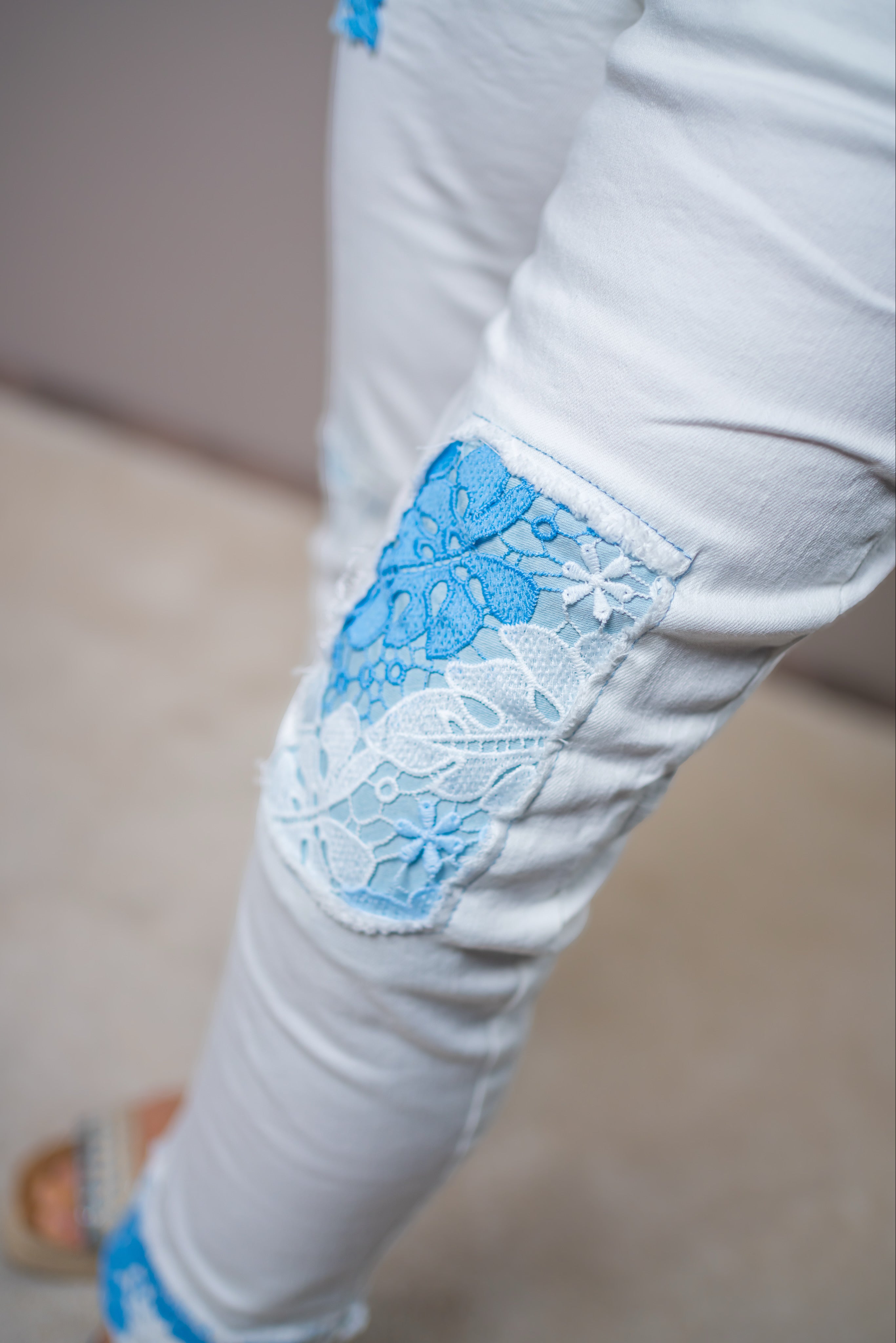 Weiße Jeans mit blauen Spitzen-Patches
