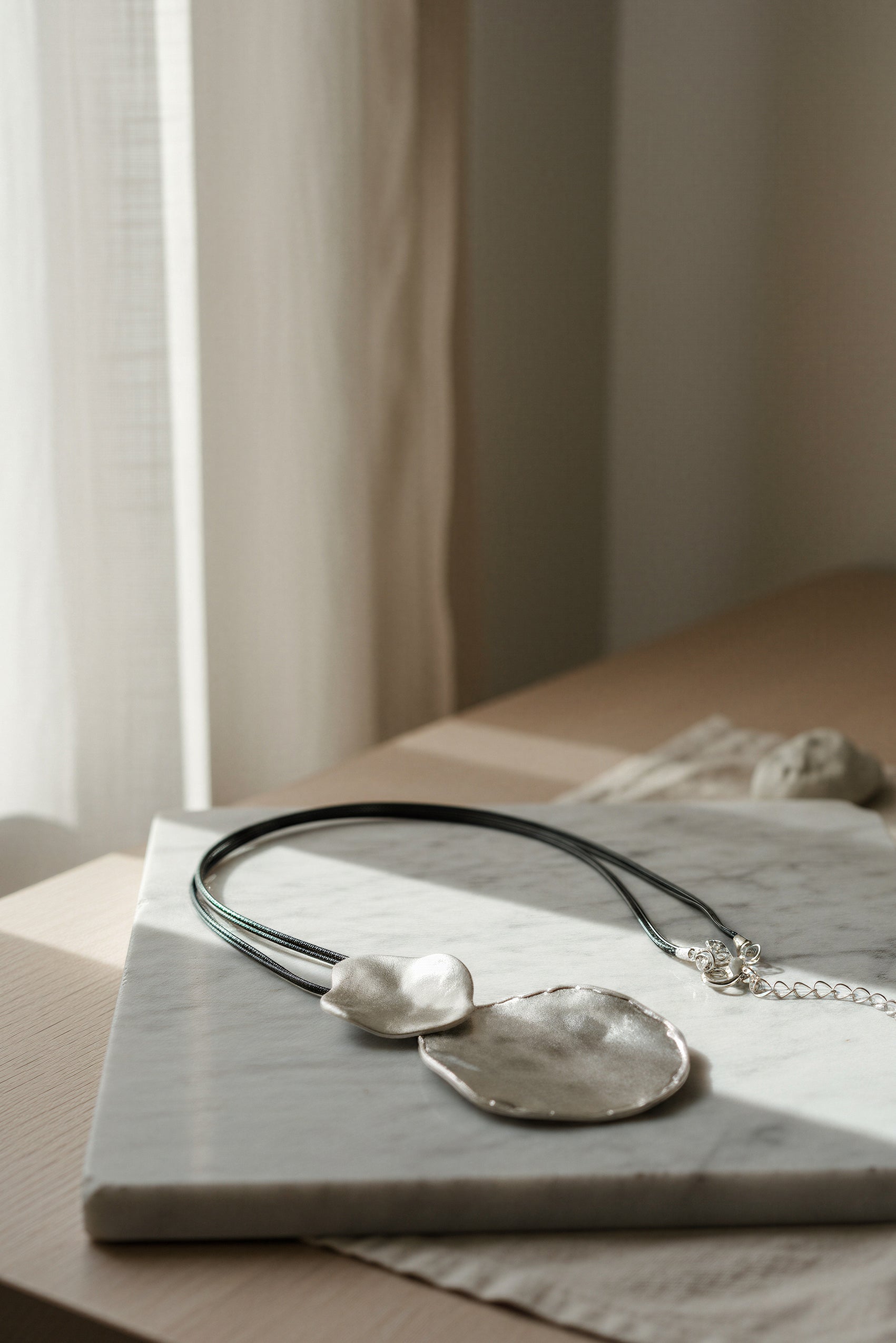 Lange Kette mit großem silberfarbenem Anhänger