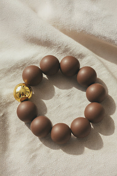 Armband aus Acryl in Dunkelbraun mit Goldkugel