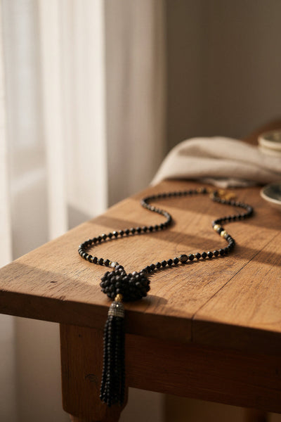 Lange schwarze Glasperlenkette mit funkelndem Herz und Steinchen-Quaste