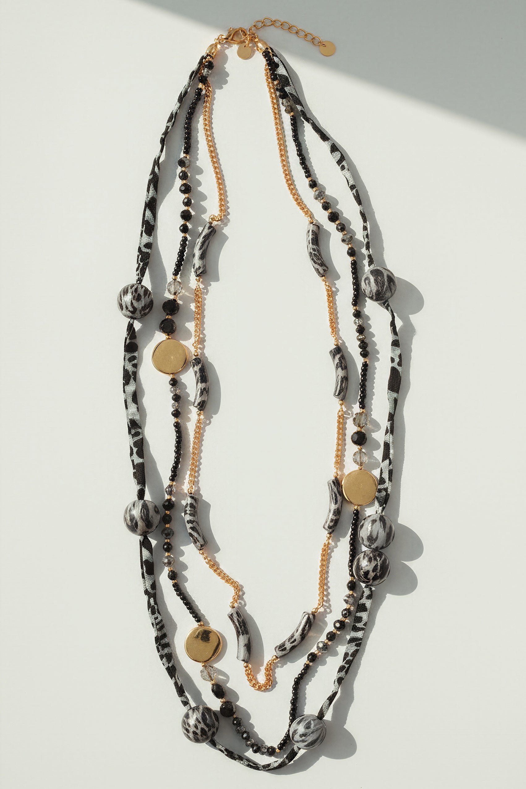 Lange Statement-Kette mit Stoffdetails und Goldakzenten