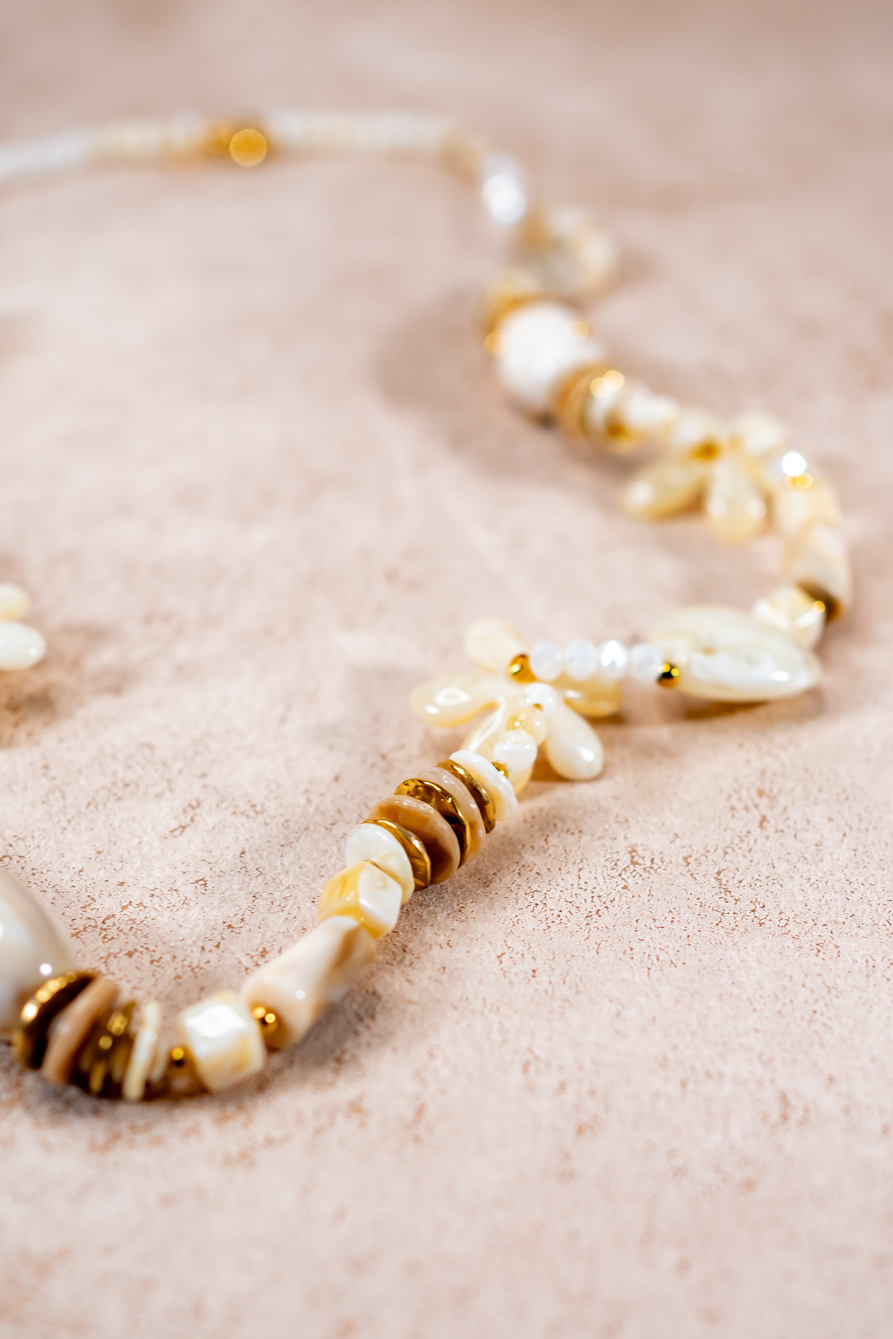 Lange Halskette in Creme mit Herz- und Blütenanhängern