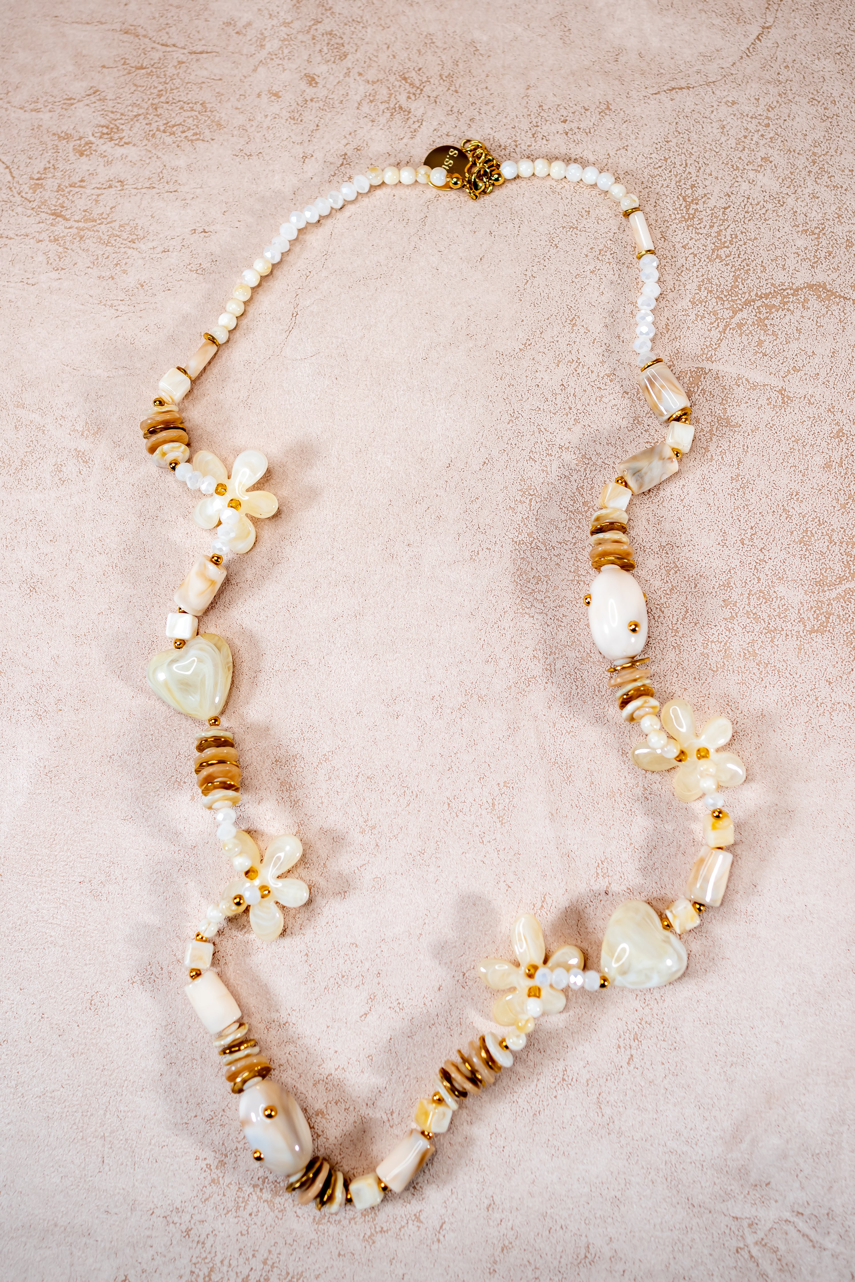 Lange Halskette in Creme mit Herz- und Blütenanhängern