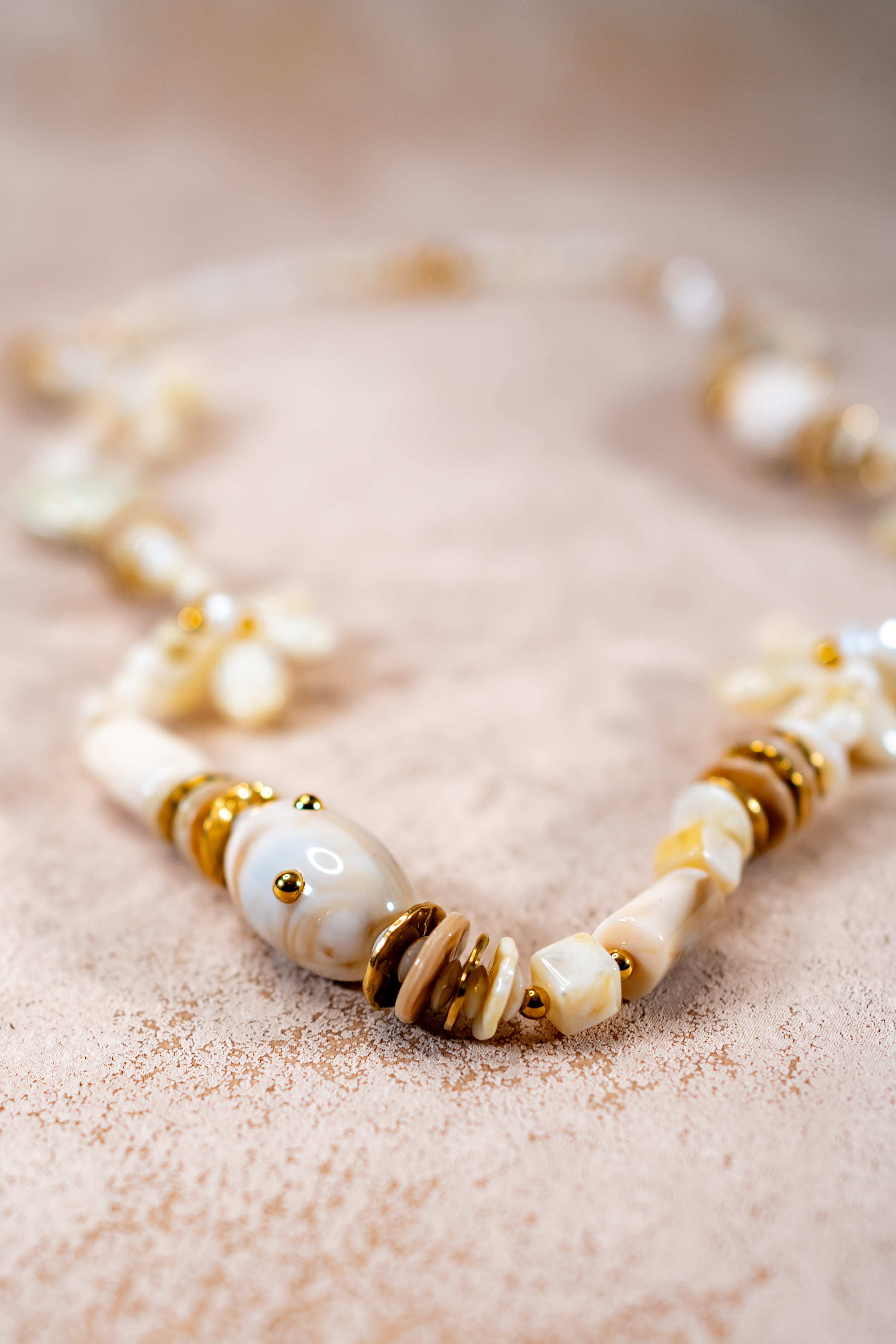 Lange Halskette in Creme mit Herz- und Blütenanhängern